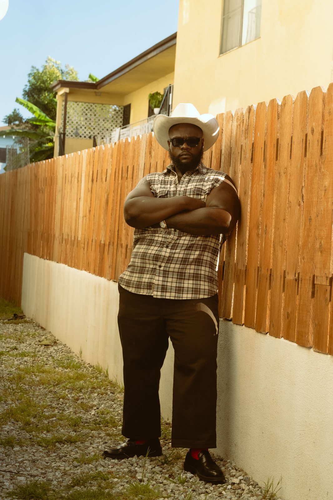 Que Heffe standing in a cowboy hat with arms crossed