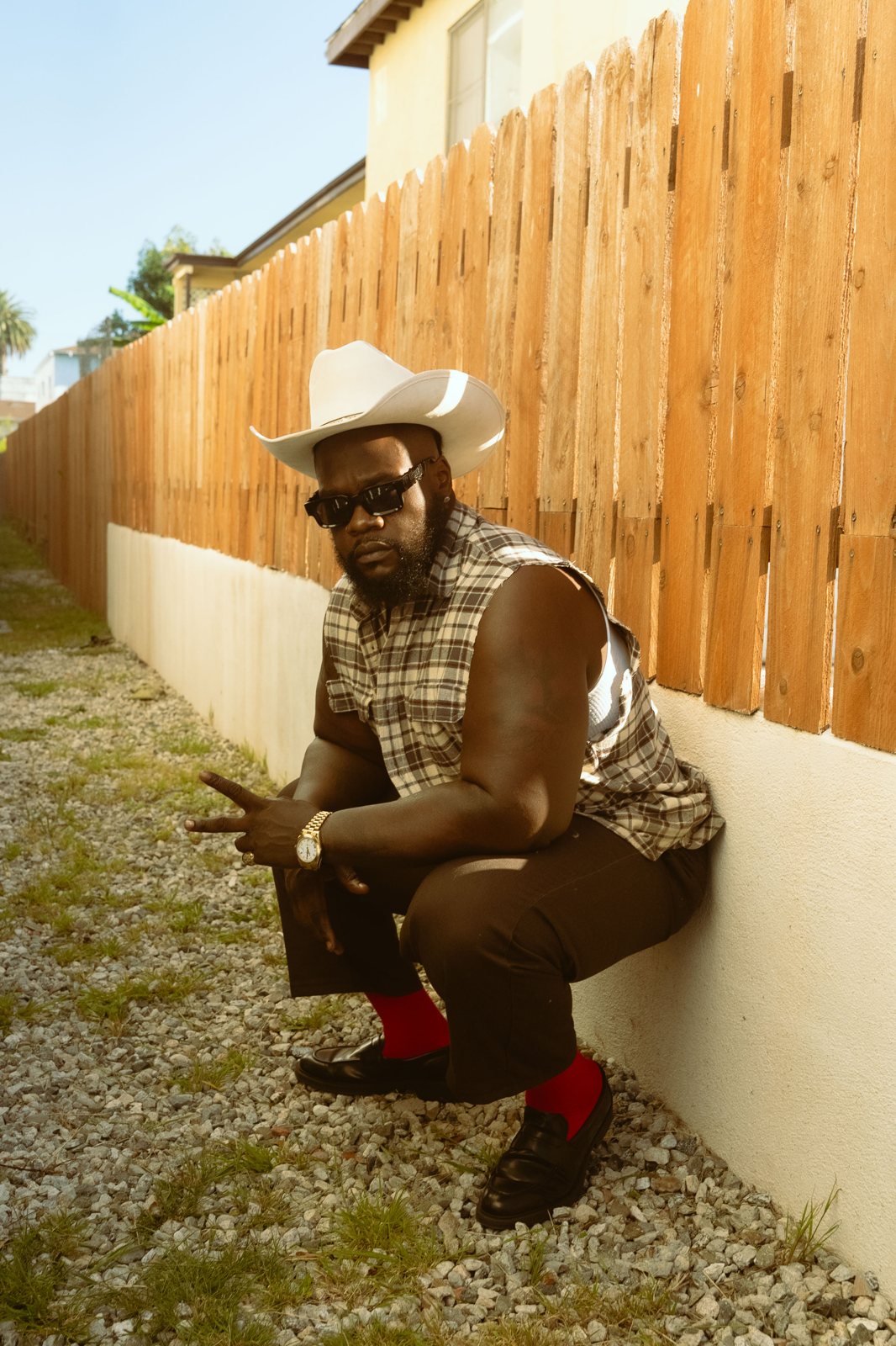 Que Heffe seated in a cowboy hat, relaxed
